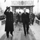 Kong Haakon vinker til folkmengden på kaia. Oslos ordfører Einar Gerhardsen til høyre. Foto: NTB scanpix