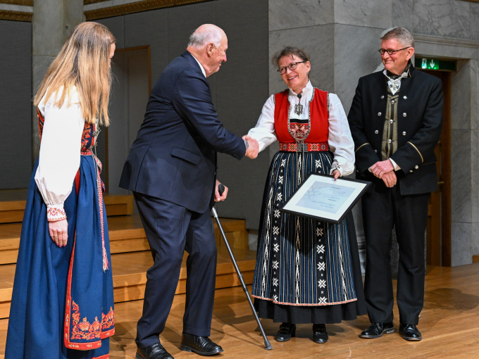Generalsekretær i Kreftforeningen Ingrid Stenstadvold Ross, Kong Harald, Åslaug Helland og og styreleder i Kreftforeningen Geir Riise under seremonien i Universitetets aula. Foto: Sven Gj. Gjeruldsen, Det kongelige hoff