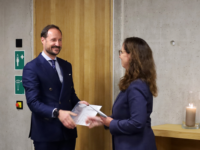 Statssekretær Gunn Karin Gjul fra byggets oppdragsgiver, Kommunal- og distriktsdepartementet, overrekker FutureBuilt-plaketten til Kronprins Haakon. Foto: Liv Osmundsen, Det kongelige hoff