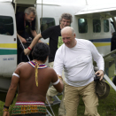 Kongen blir tatt imot av en representant for yanomami-indianerne på den gressbelagte rullebanen. Publisert 04.05 2013. Handoutbilde fra Det kongelige hoff. Bildet er kun til redaksjonell bruk - ikke for salg. Foto: Rainforest Foundation Norway / ISA Brazil.